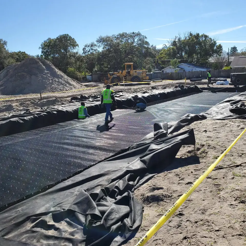 Workers finish installing the Geogrid layer.
